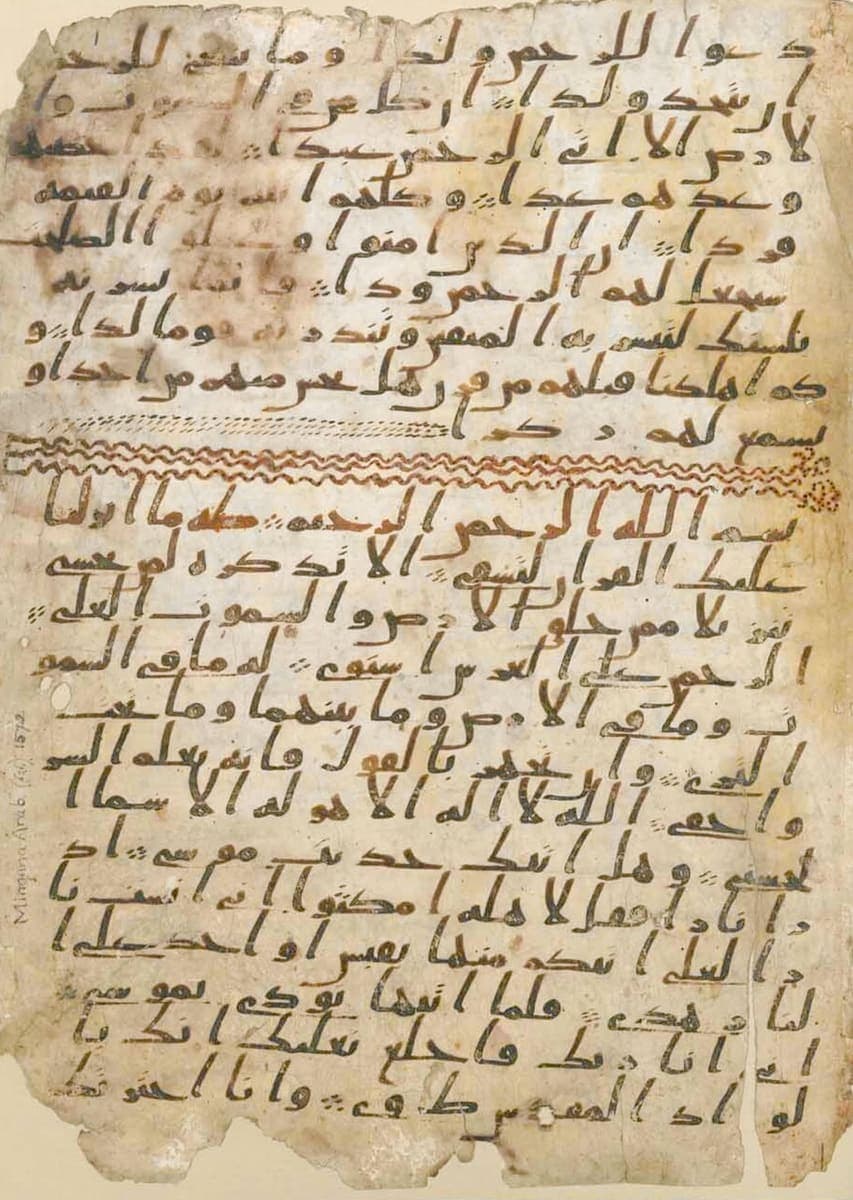 Parchment folio in sloping hijazi script, nine lines of text above an ornamental band of red waves and a further thirteen lines below it