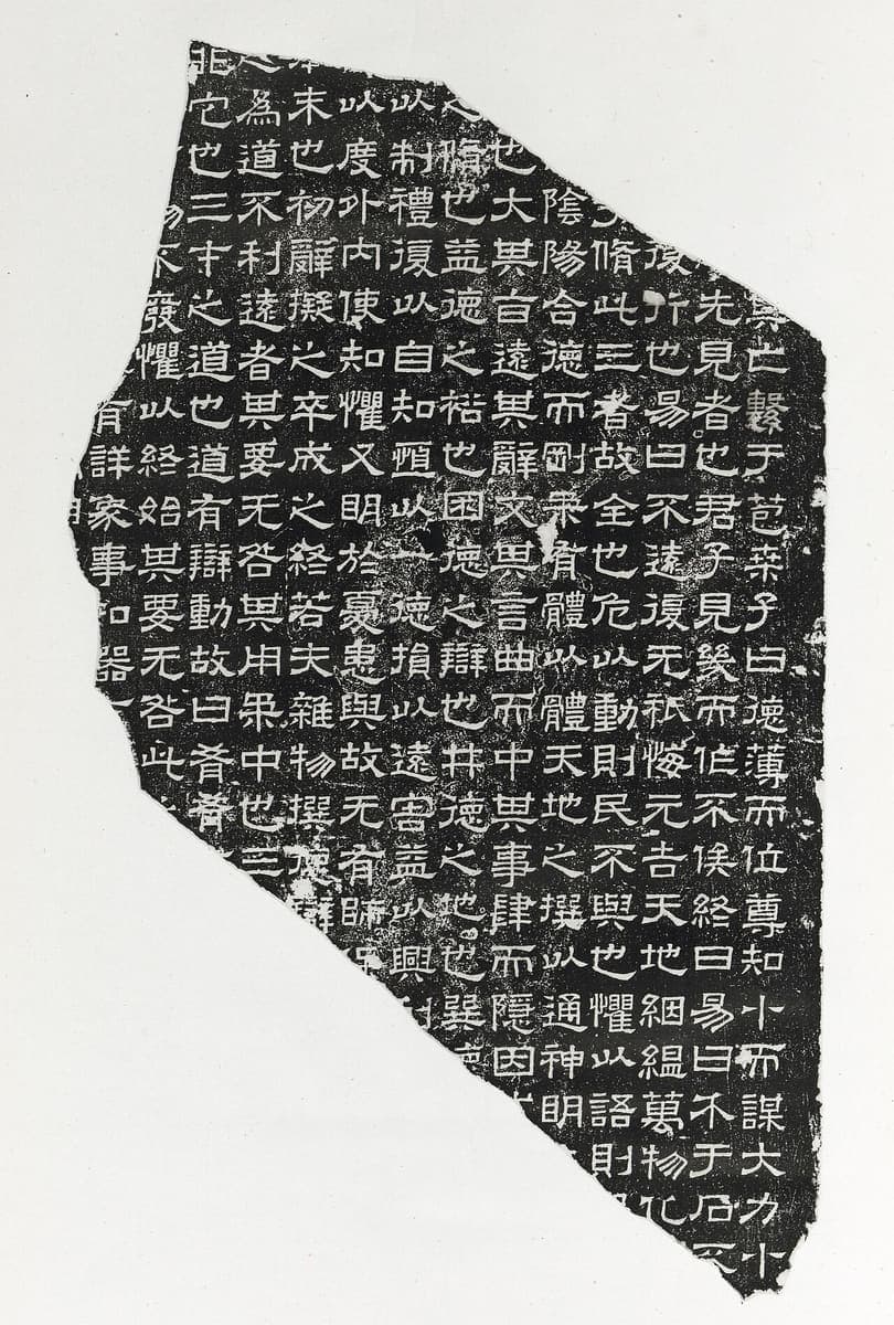 Rubbing of a broken stone slab, white clerical characters in an even grid, the fragment outline jagged against a pale ground