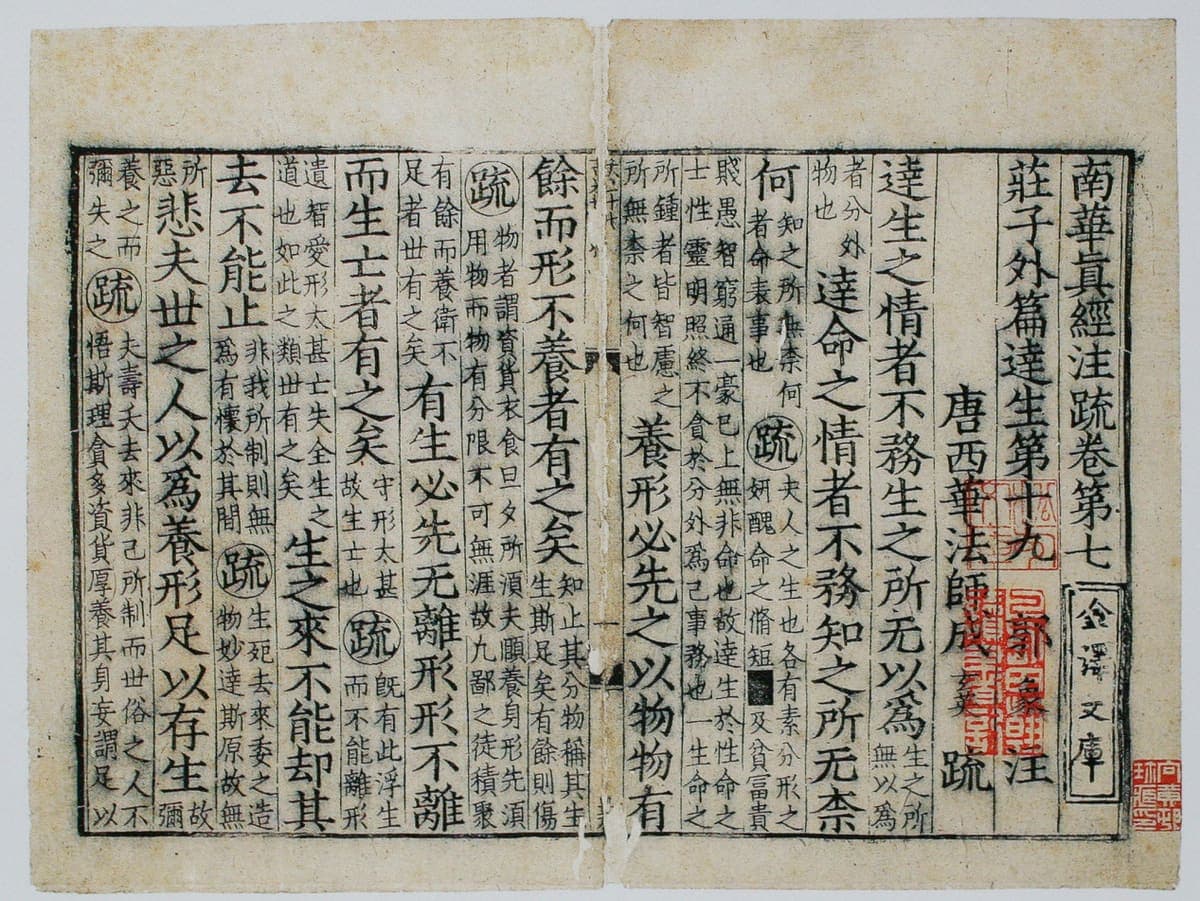 Two facing leaves of a Song printed book, large characters interrupted by blocks of small text in double columns, with red seals