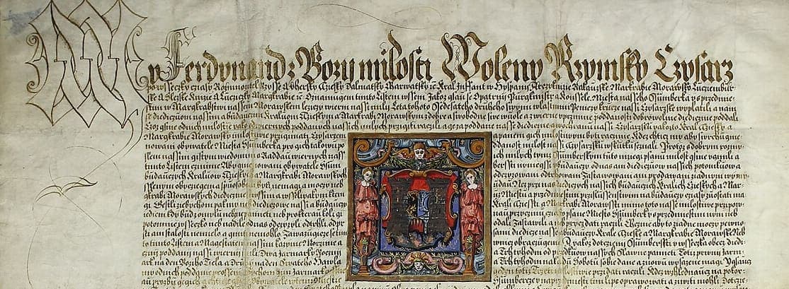 Upper part of a parchment charter with an enormous calligraphic first line and a dense block of chancery text below, interrupted by a painted coat of arms