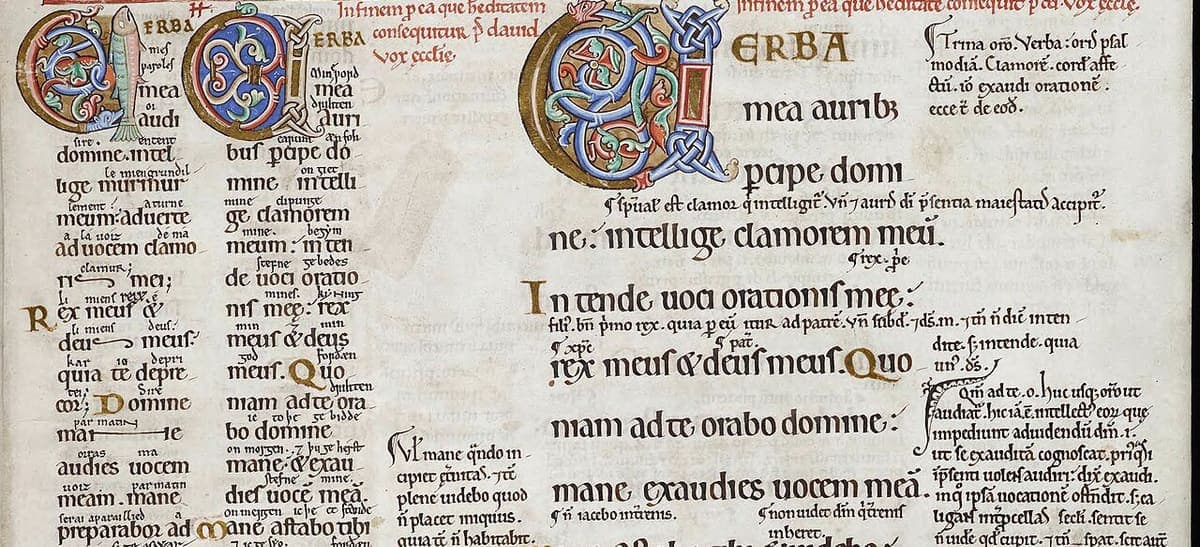 Band across a page of the Eadwine Psalter showing three columns of Latin psalm text with tiny interlinear glosses and decorated initials
