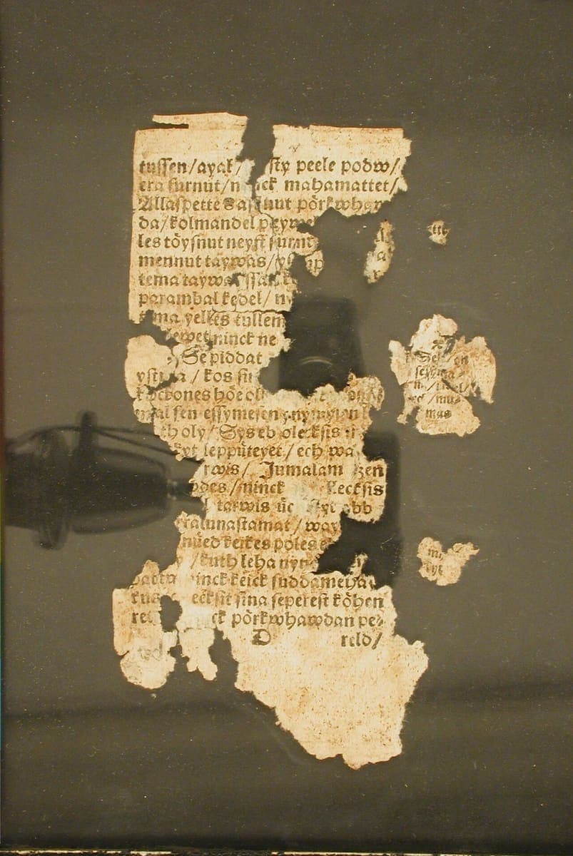 Fragmentary damaged page of the 1535 Wanradt-Koell catechism in Fraktur type, with holes and torn edges