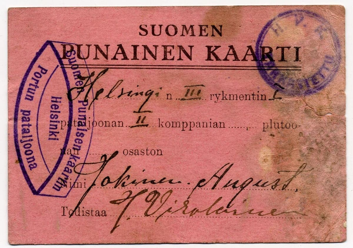 Pink printed membership card of the Finnish Red Guard from 1918 with handwritten regiment details and two purple stamps