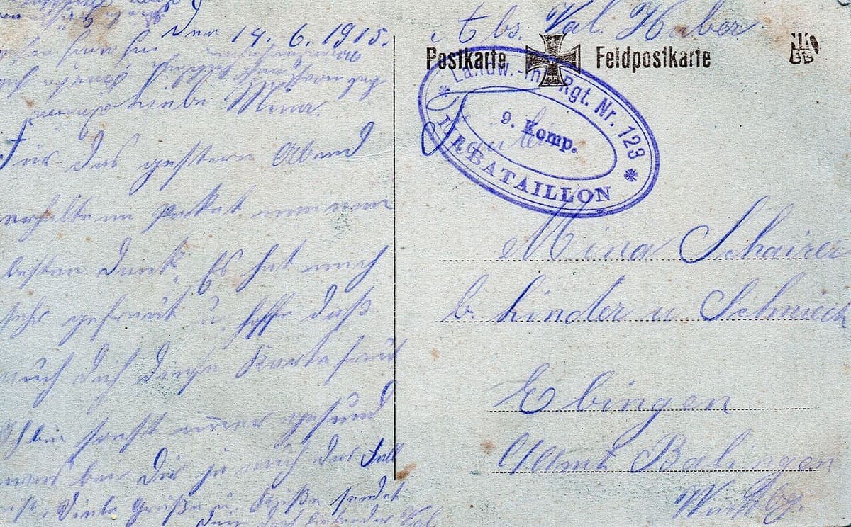 Back of a First World War field postcard with a handwritten message on the left, a printed Feldpostkarte heading and a regimental stamp on the right