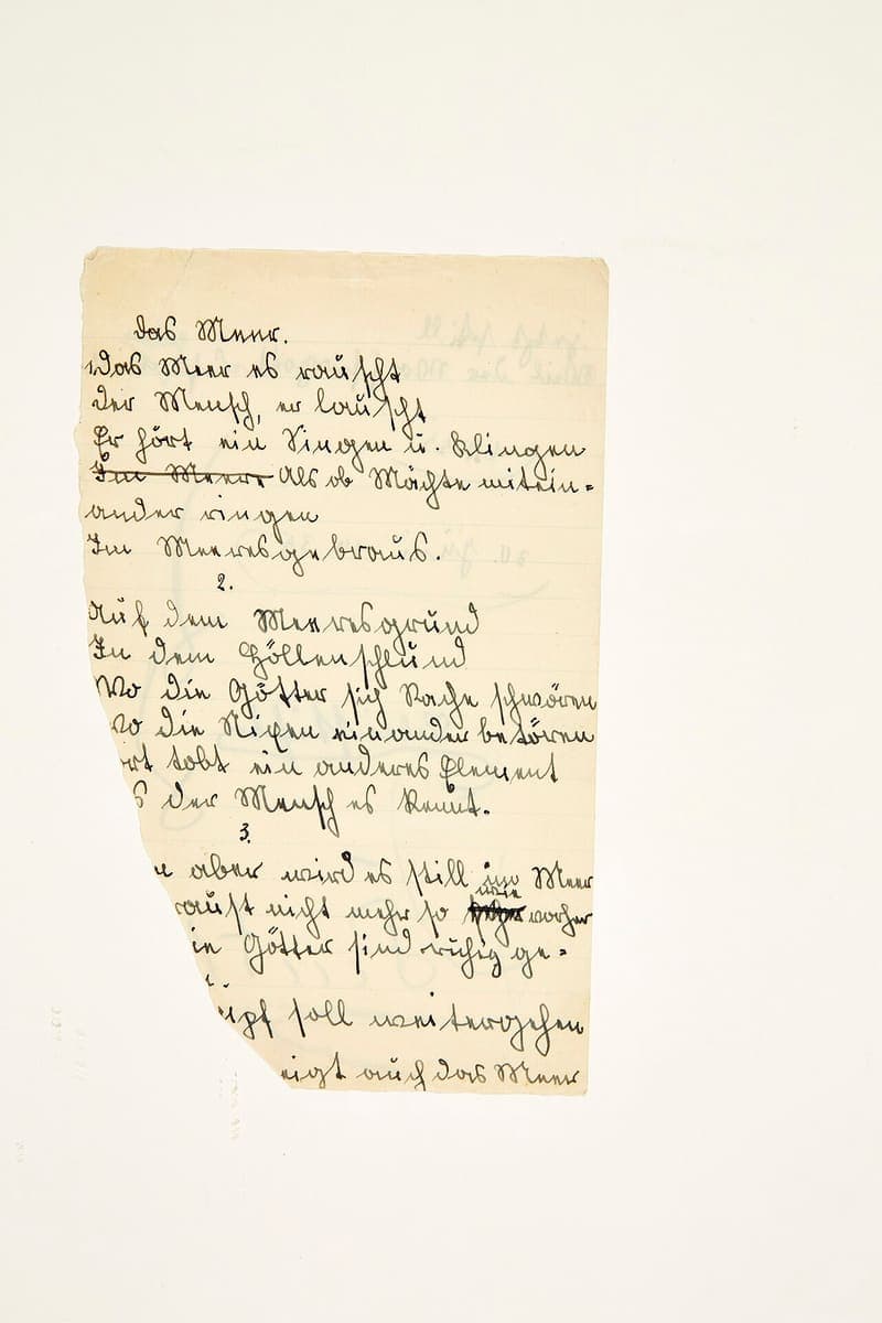 Handwritten draft of a poem on a torn sheet of paper, in upright Sütterlin-influenced cursive with two struck-out passages and a correction inserted above one of them