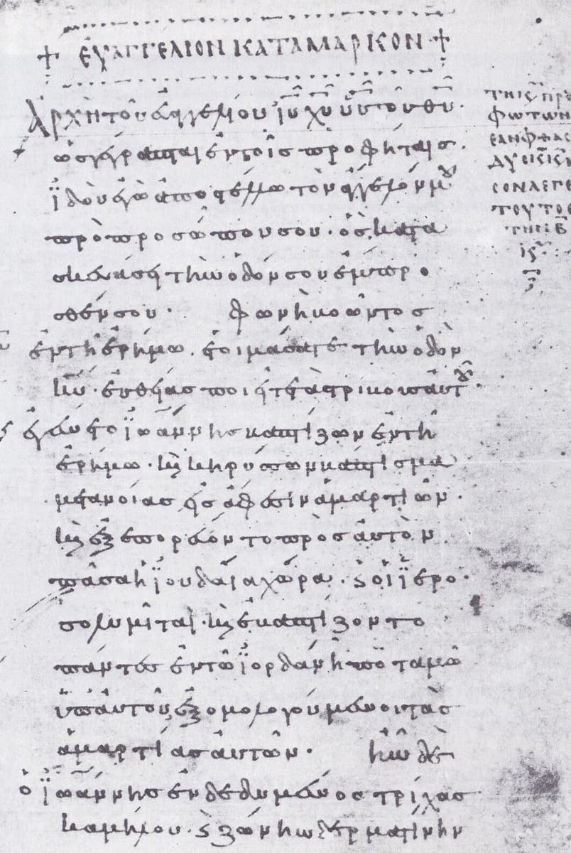 Parchment page with a majuscule title above small early minuscule writing, with letters and notes in the margins
