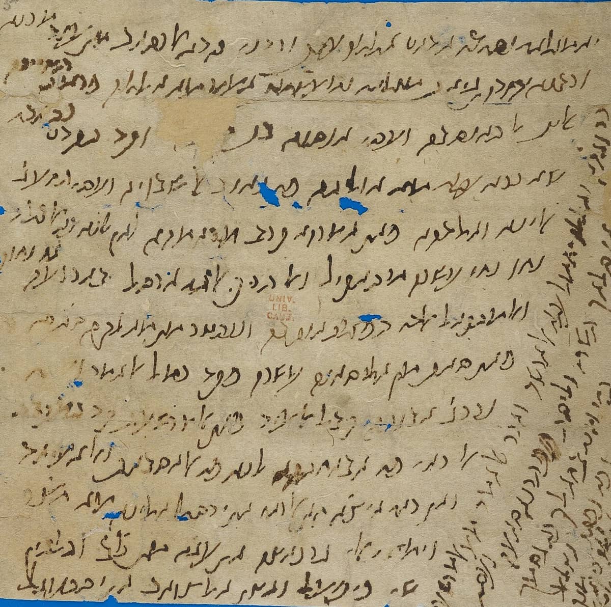 Paper letter written in a sloping Judeo-Arabic cursive, with further lines written vertically up the right-hand margin and holes through the sheet