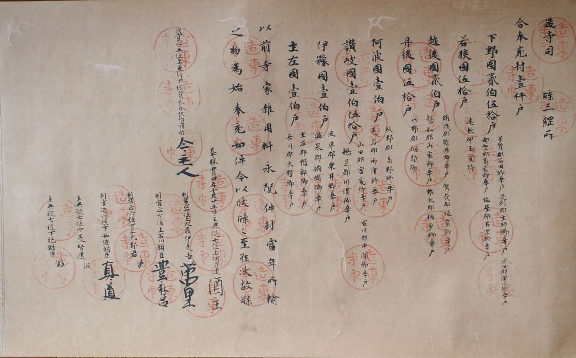 Nara-period Japanese official document in columns of Chinese characters with large round vermilion seals stamped across the text
