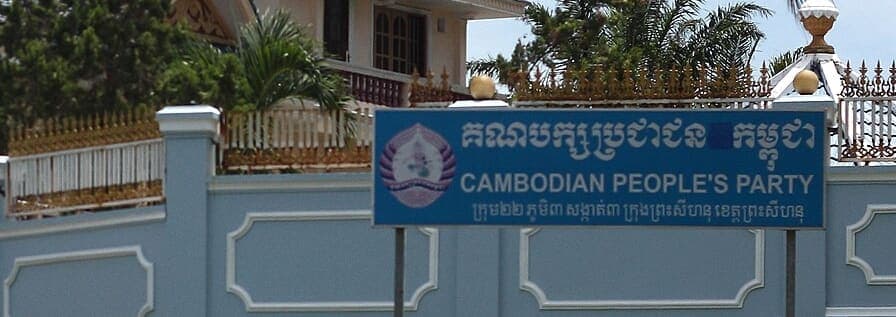 Blue roadside signboard reading Cambodian People’s Party in Khmer headline script above an English translation and a smaller line of Khmer