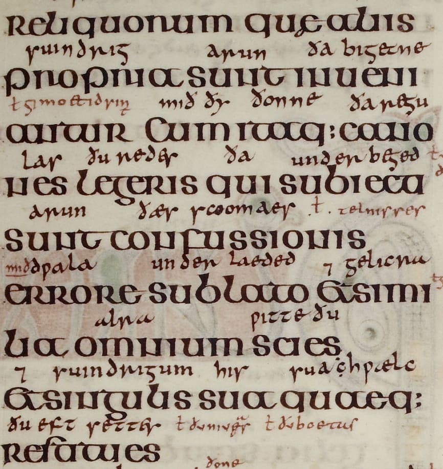 Nine lines of broad Insular half-uncial Latin with a smaller, browner Old English gloss written between the lines