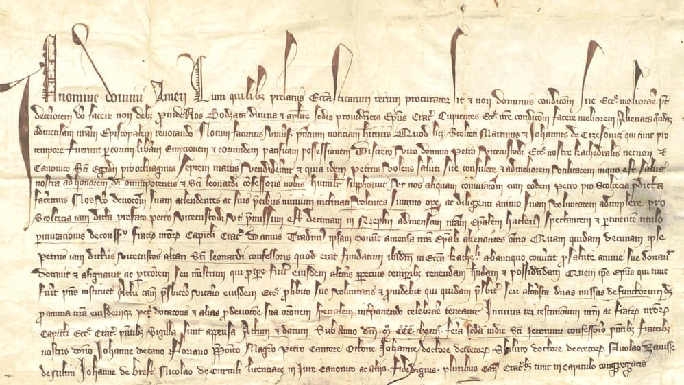 Fourteenth-century episcopal charter with a first line of very tall looping display letters above fifteen lines of compressed Gothic cursive
