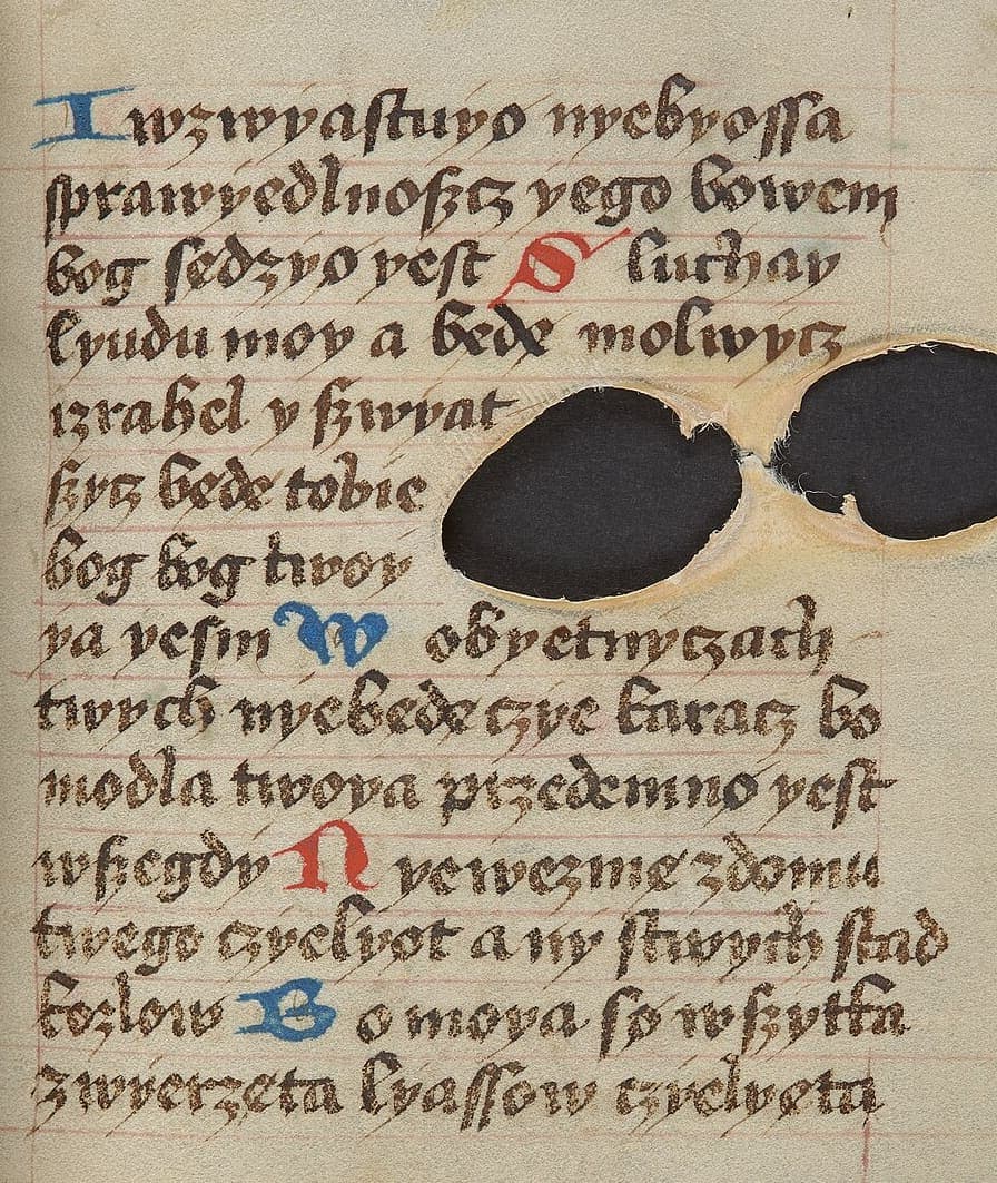 Parchment leaf with fourteen lines of Polish bastarda between red ruling, coloured initials in blue and red, and two large natural holes in the skin that the text runs around