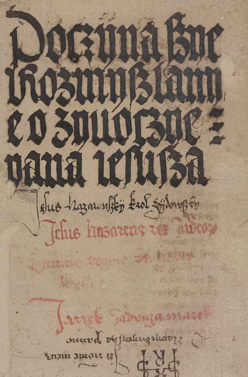 Manuscript title page with four lines of very large black Gothic display letters, a red line of Latin below, and faint later cursive additions