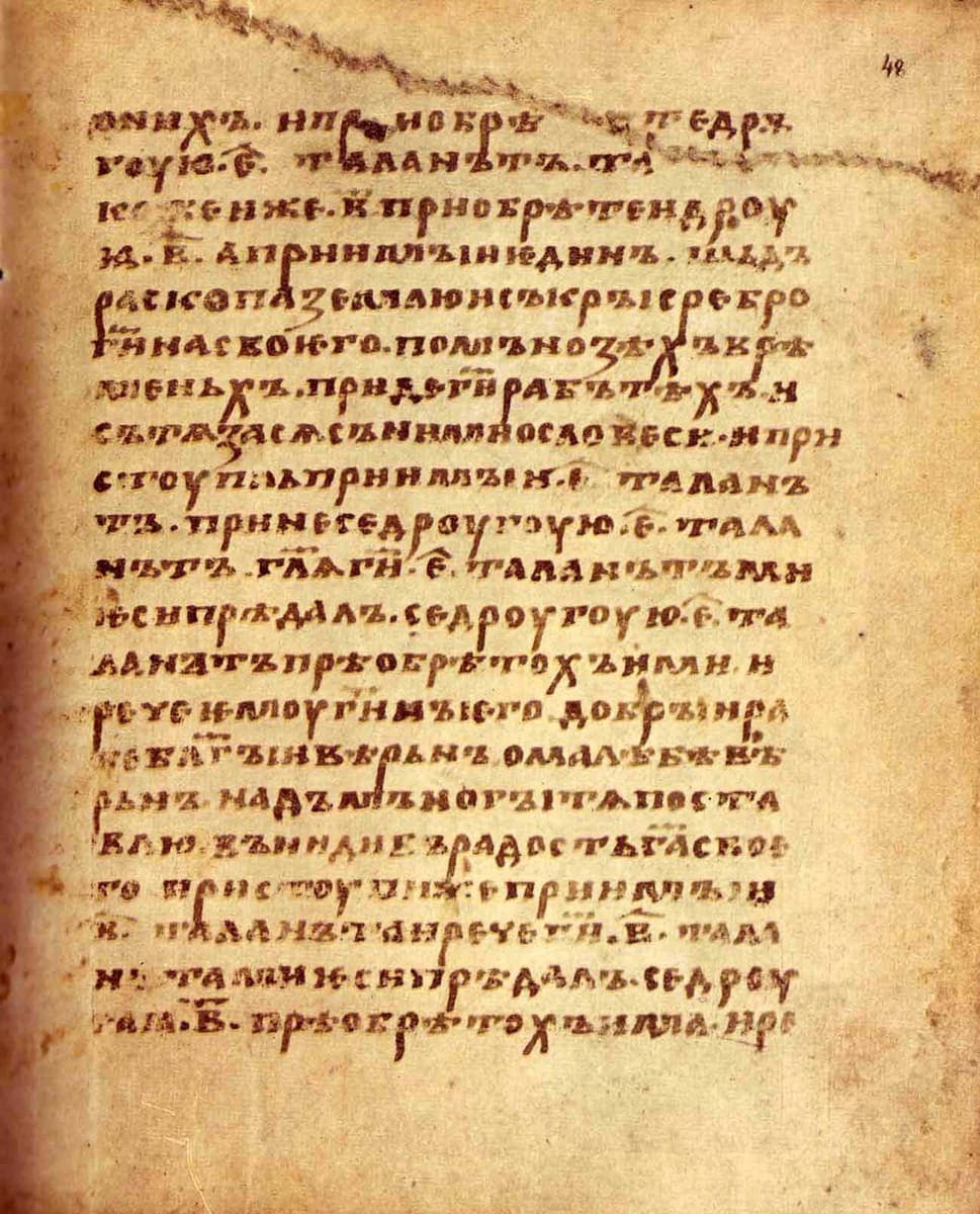 Single column of large brown ustav on parchment, twenty-one lines with several small letters and numerals set above the line