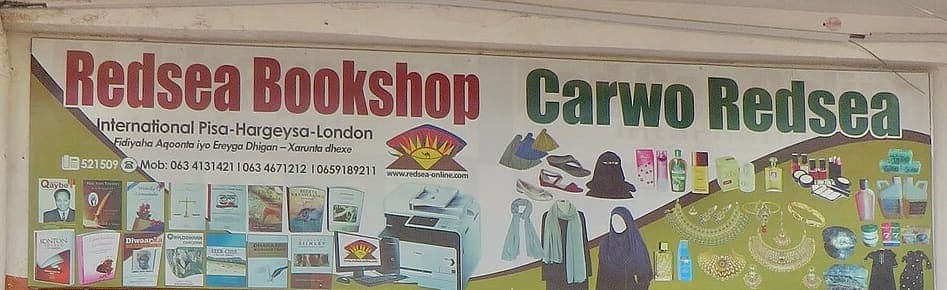 A shopfront signboard reading Redsea Bookshop and Carwo Redsea above a smaller line of Somali text, with product illustrations along the bottom