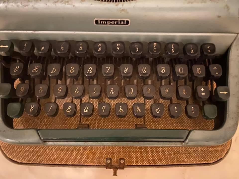 The keyboard of an old Imperial-brand typewriter, its keys engraved with the curved letters of the Osmanya alphabet instead of Latin letters