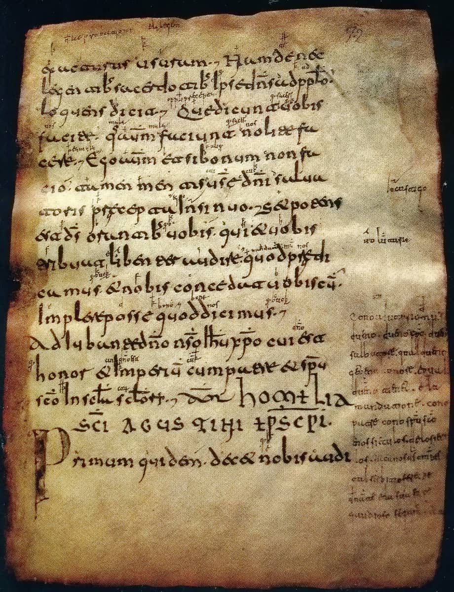 Parchment page in Visigothic minuscule with many small interlinear glosses and a twelve-line marginal gloss in the lower right margin.