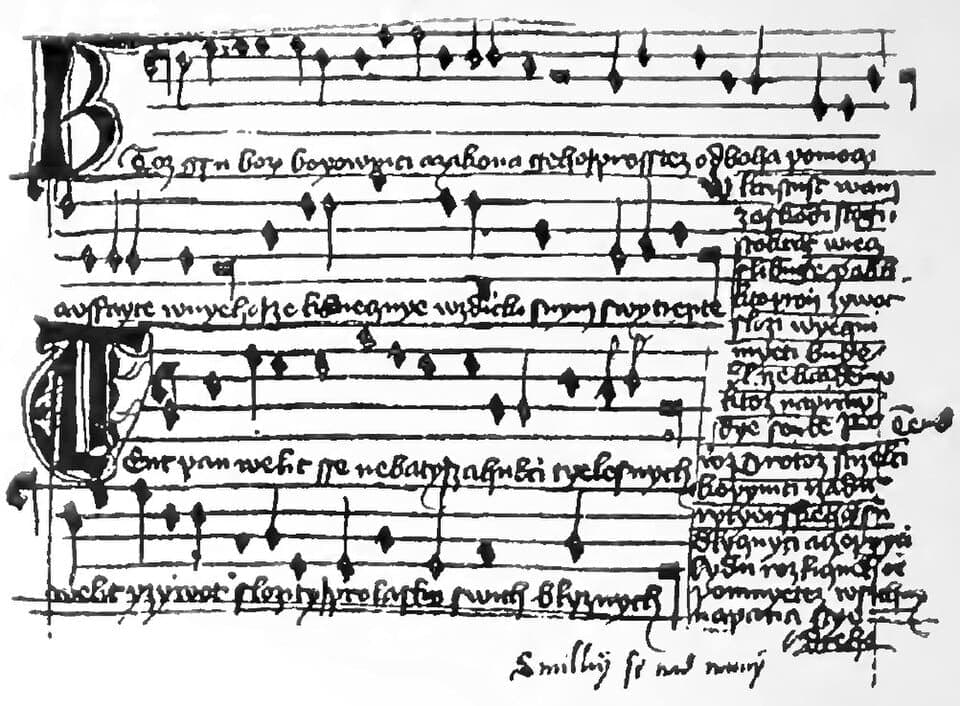 High-contrast facsimile of a hymnal page, four staves of black notes with Czech words under them and further stanzas in a narrow column at the right