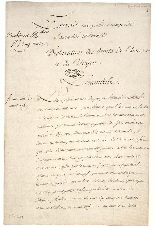 A large sheet headed with a calligraphic title in flowing shaded letters, the preamble below in a fine sloping clerk’s hand, with registration notes and a date written in the left margin