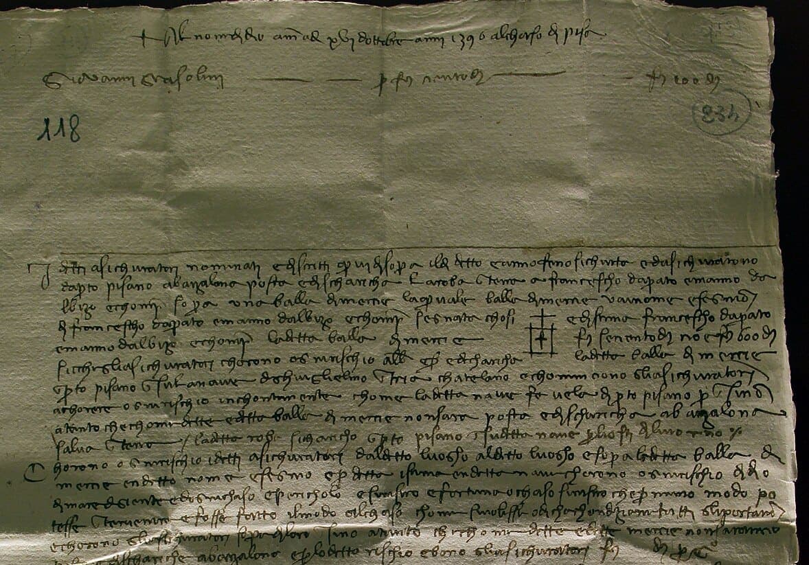 A single paper sheet of 1395 covered in small mercantesca, with an invocation and date across the top and each clause of the contract marked by a paraph in the left margin