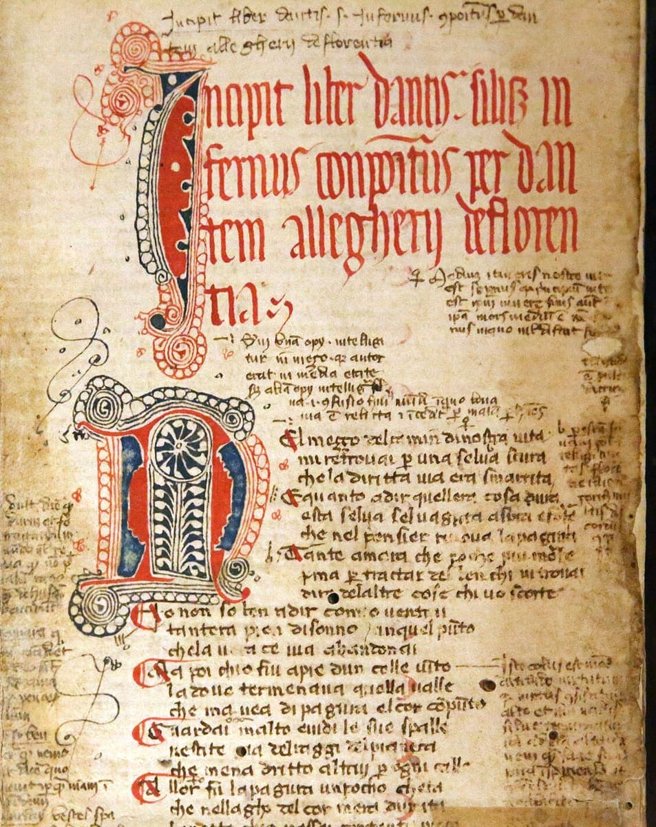 Opening page of the Inferno in Laurenziana Plut. 40.22, with a red Latin incipit, a pen-flourished initial N, tercets in rotunda textualis and dense marginal glosses in a smaller hand