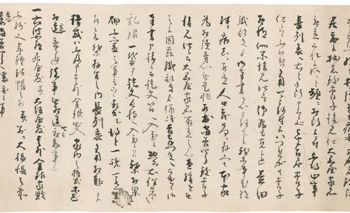 Section of a handscroll covered in fast connected cursive characters, with a small stamped seal low in the middle of the sheet
