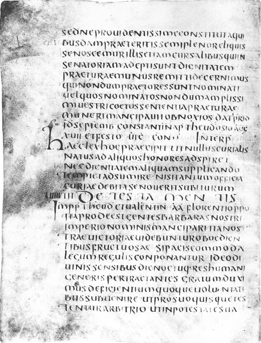 Page of black uncial script from a sixth-century law book, with a heading in widely spaced letters reading DE TESTAMENTIS across the middle