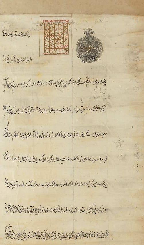 A tall document with a gold tughra in a red frame beside a round black seal, above six widely spaced lines of Persian and a dense block of small writing at the foot