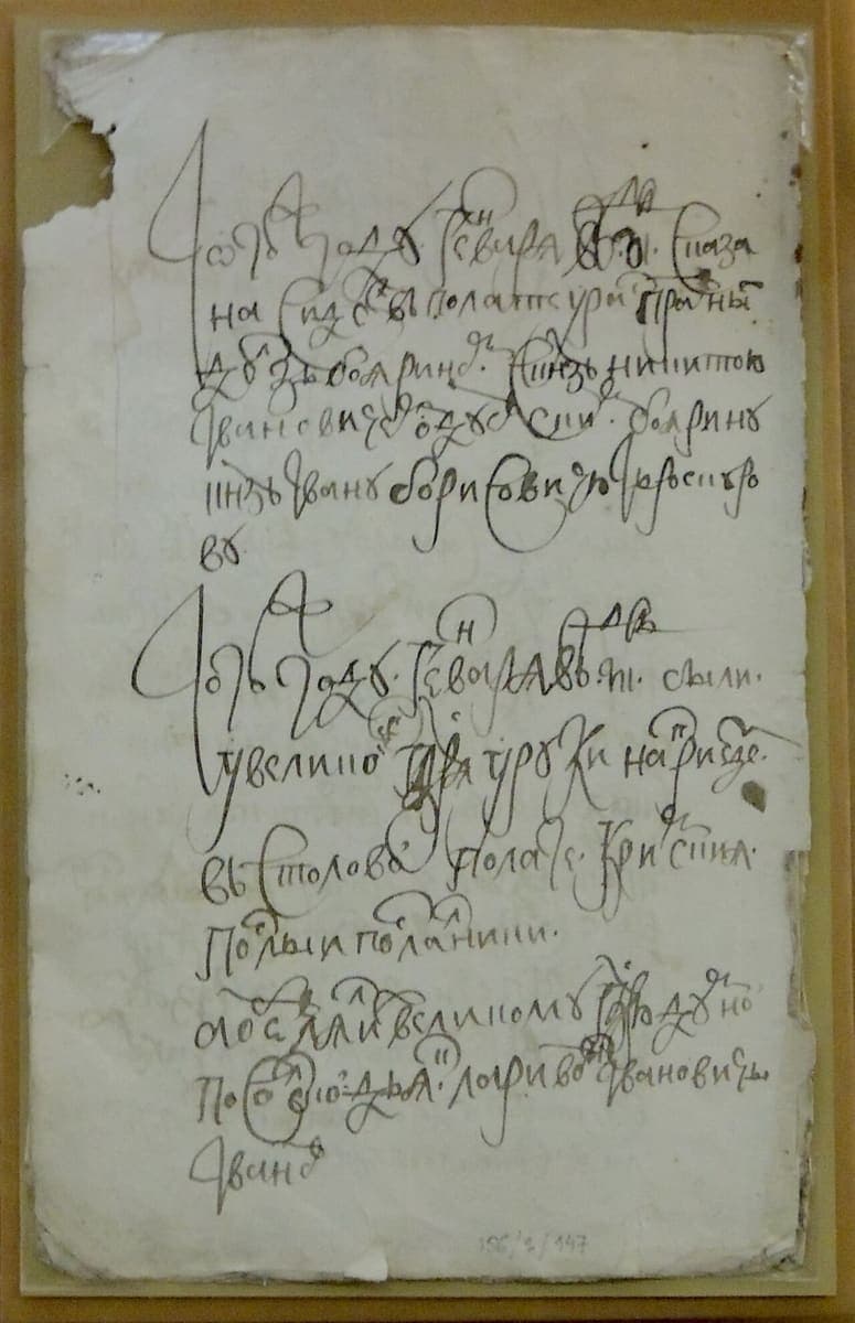Sheet with three paragraphs of very large looping cursive, the first two each opening with an oversized decorated letter