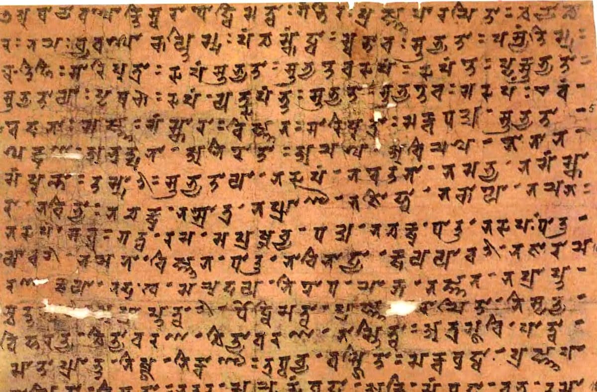 Sheet of tinted paper covered in some fifteen lines of Siddham writing with small interpunct dots between syllables and modern line numbers in the right margin